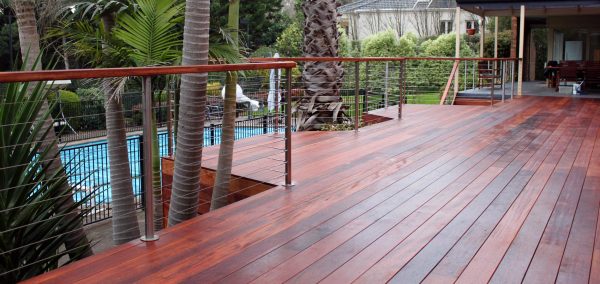 Split level Merbau deck with built-in lighting overlooking swimming pool Custom built Merbau deck, Templestowe with split levels, stairs, and built-in deck lighting.